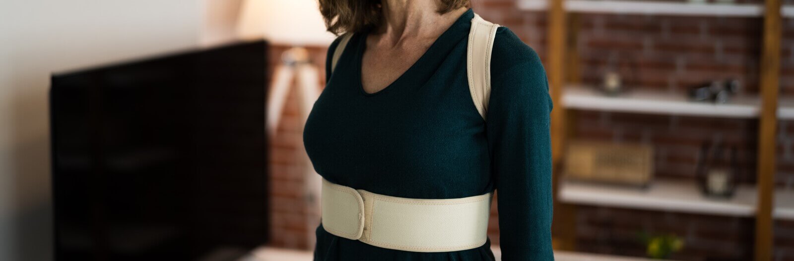 Woman wearing a posture corrector in her house