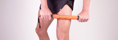 A young man doing massage to itself with stick massagers