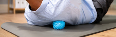 Man in office using massage ball for trigger point release