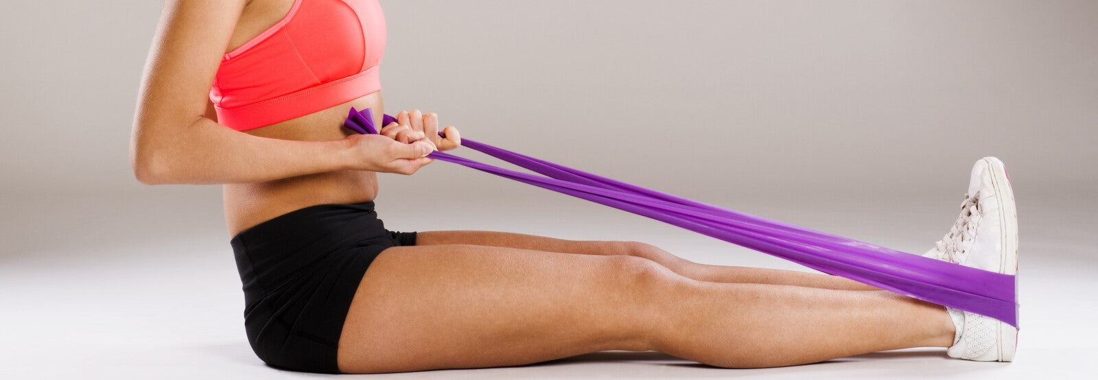 Young woman athlete exercising with resistance band 