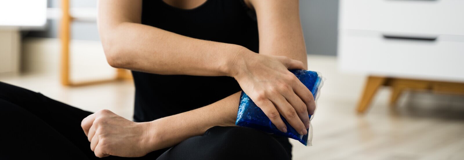 Young lady treating back pain using hot/cold therapy