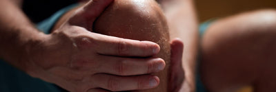 A runner clutches his knee due to pattelar tendonitis