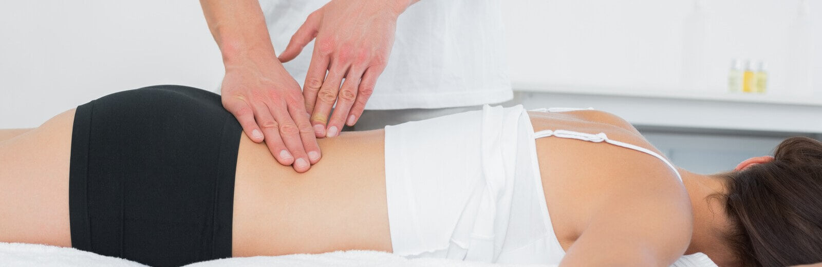 Doctor examining womans painful back due to herniated disc symptoms